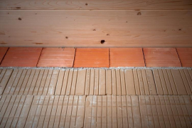 Der obere Deckenanschluss zur Holzdecke wird mittels einer Ziegel-U-Schale und Mörtel-Ausgleichsschichten ausgeführt, um Setzungen schadlos aufzufangen. Foto: Bauhaus Filmwerkstatt