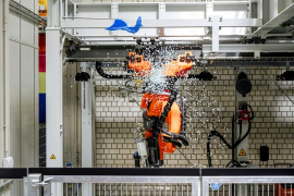 Alle halten die Luft an. Der Roboter peilt mit seinem Werkzeugt den Ballon an. Dann: Konfetti! Das neue Großgerät ist eingeweiht. 
